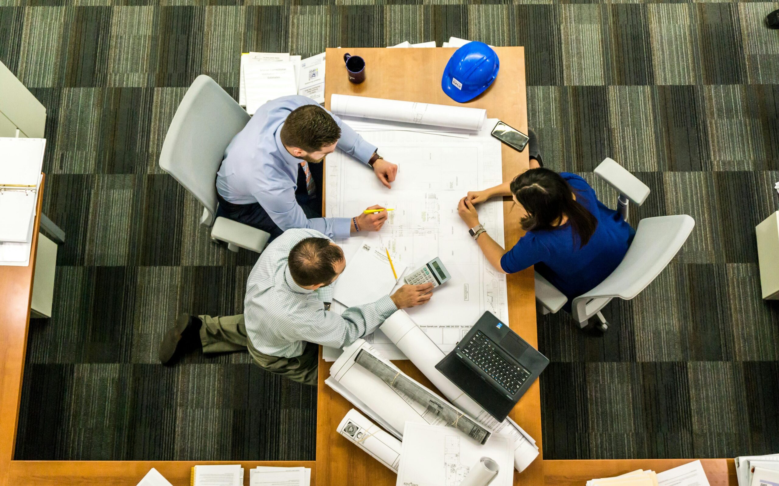 Top view of a team working on construction plans in an office setting. Professional Improvement Goals